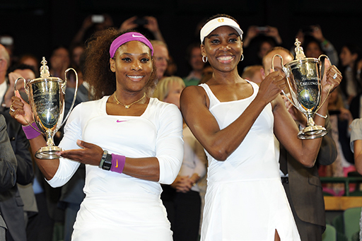 Serena and Venus Williams pose with the Ladies' doubles championship trophies.